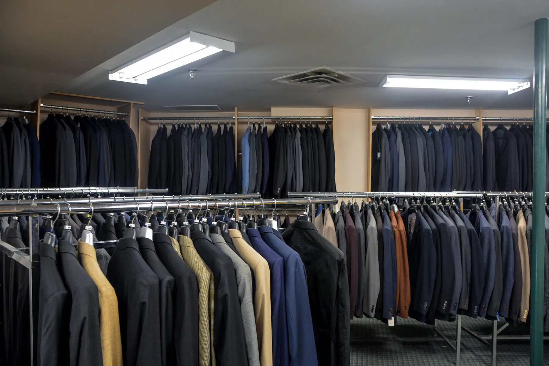 Man About Town Suit Shop Interior With Suits Hanging On Racks